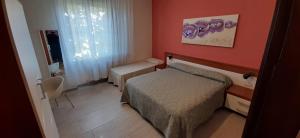 Cette petite chambre comprend un lit et une fenêtre. dans l'établissement Albergo La Quiete, à Desenzano del Garda