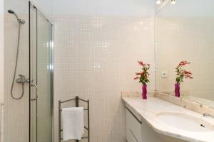 een badkamer met een wastafel en een glazen douche bij Ilda's Home - Big Families & Groups in Porto