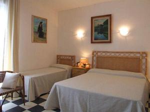 een hotelkamer met 2 bedden en een raam bij Nautilus 3+2 in Marina di Castagneto Carducci