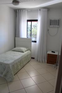 מיטה או מיטות בחדר ב-Apartamento com área externa na Bacutia - uma quadra do mar
