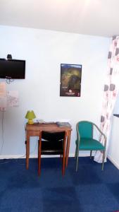 a desk and a chair in a room at Hotel Le Gambetta in Carmaux