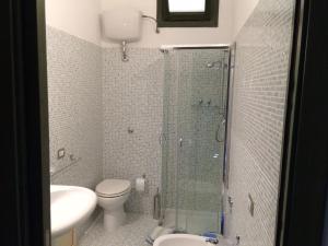 a bathroom with a shower and a toilet and a sink at Cottage Su Giudeu in Chia