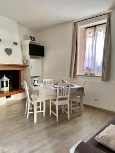 comedor con mesa, sillas y chimenea en B&B La Piccola Corte, en Polpenazze del Garda