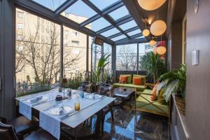a conservatory with tables and chairs in a restaurant at Eclat Luxury Hotel in Belgrade