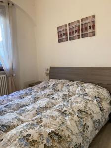 uma cama com um edredão num quarto em B&B La Piccola Corte em Polpenazze del Garda