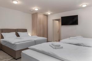 a bedroom with two beds and a flat screen tv at The Base in Zagreb