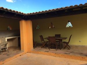 a patio with a table and chairs and a fireplace at Cottage Su Giudeu in Chia +13 photos