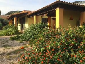 a house with flowers in front of it at Cottage Su Giudeu in Chia