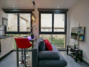 een woonkamer met een blauwe bank en een rode stoel bij Le Drouhouse + parking privé in Nancy