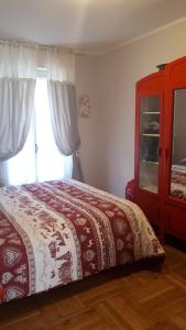 een slaapkamer met een bed met een rode dressoir en een raam bij Appartamento Limone Piemonte in Limone Piemonte