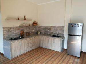 a kitchen with wooden cabinets and a refrigerator at Jogja City Residence in Yogyakarta