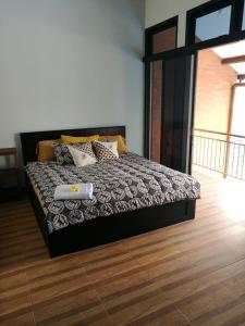 a bedroom with a bed with a black and white comforter at Jogja City Residence in Yogyakarta