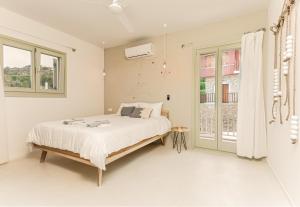 a white bedroom with a bed and a window at Sea and Sun Luxury Pools' Villas in Chorefto