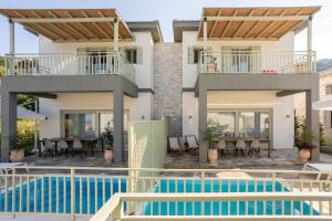a villa with a swimming pool and a house at Sea and Sun Luxury Pools' Villas in Chorefto