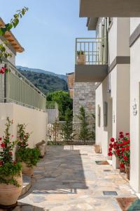 a walkway between two buildings with red flowers at Sea and Sun Luxury Pools' Villas in Chorefto