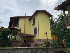 uma casa amarela ao lado de uma rua em Casailhabela em Ilhabela