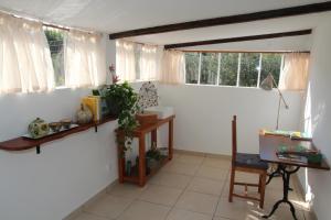 Habitación con paredes y ventanas blancas y mesa. en le cabanon de l'olivette, en Istres