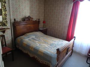 um quarto com uma cama e uma cortina vermelha em Charming French cottage in the heart of quiet Gorron em Gorron