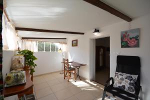 een woonkamer met een tafel en een stoel bij le cabanon de l'olivette in Istres