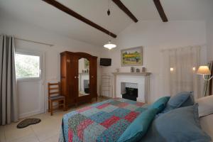 een slaapkamer met een bed en een open haard bij le cabanon de l'olivette in Istres