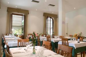 ein Restaurant mit weißen Tischen und Stühlen, die mit Blumen geschmückt waren in der Unterkunft Hotel Vittoria in Viareggio