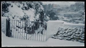 a gate covered in snow next to a garden at Casa Rural Casa Gimeno in Bocairent