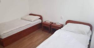 two beds in a room with two night stands at Lánchíd Szálló in Kecskemét
