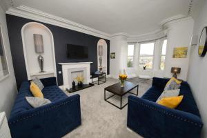 a living room with two blue couches and a fireplace at No 48 Castle View in Inverness