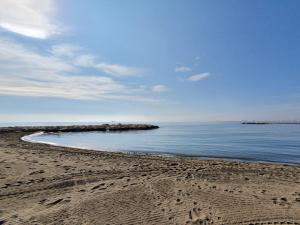 a beach with footprints in the sand and the ocean at El Nogal Home in Málaga