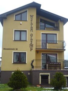 a yellow building with a sign on it at Willa Olimp in Władysławowo