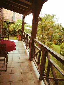 - une terrasse couverte d'une maison avec une table et une vue dans l'établissement L'ESTAGNON, à La Plaine des Cafres