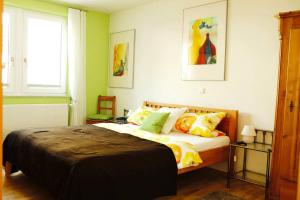 a bedroom with a large bed with colorful pillows at Weingut Schunck in Leinsweiler