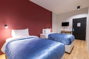 a hotel room with two beds and a tv at Nap Hotel in Chiang Rai