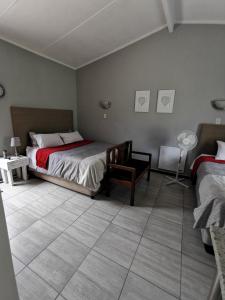 a bedroom with two beds and a tiled floor at Stew s Room in Polokwane