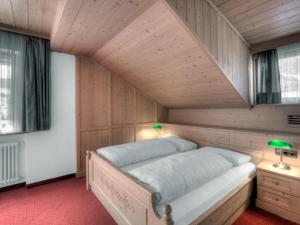 1 dormitorio con 1 cama en una habitación de madera en B&B Bracun, en Corvara in Badia
