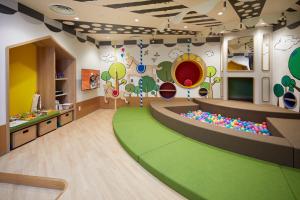a childrens playroom with a green floor and a play room at Citadines Namba Osaka in Osaka