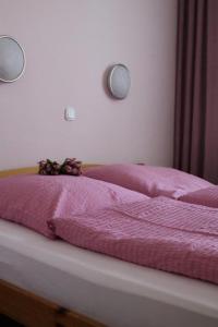 ein Bett mit einer rosa Decke und Blumen darauf in der Unterkunft Hotel Weile in Weiden