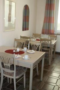 a dining room with white tables and chairs at Hotel Weile in Weiden