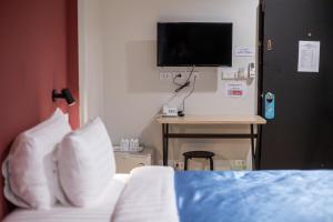 a bedroom with a bed and a tv on a wall at Nap Hotel in Chiang Rai +22 photos