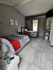 1 dormitorio con 2 camas y mesa con lámpara en Stew s Room, en Polokwane