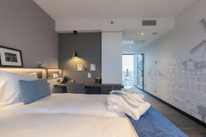 a bedroom with a large white bed with towels on it at Postillion Hotel Amsterdam in Amsterdam +76 photos