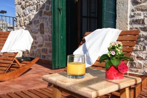 un vaso de zumo de naranja y un jarrón de flores sobre una mesa en Villa Idassa, en Zadar
