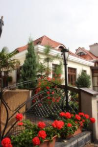 コニンにあるHotel Pałacyk Koninの柵前の赤い花の家