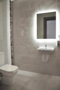 a bathroom with a toilet and a sink and a mirror at Axxodia Residence New Cairo in Cairo