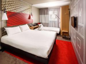 a hotel room with two beds and a red carpet at ibis London City - Shoreditch in London