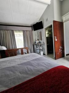 1 dormitorio con 1 cama grande con alfombra roja en Stew s Room en Polokwane