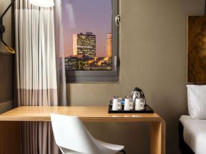 a desk in a hotel room with a view of a city at ibis London City - Shoreditch in London