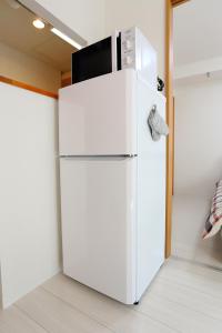 a white refrigerator with a microwave on top of it at Near Nakajima park Close to Susukino Anbiennte 101 in Sapporo