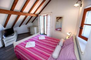 a bedroom with a pink bed in a attic at Villa Idassa in Zadar