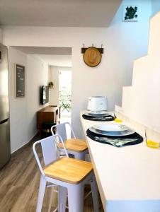 烏貝達的住宿－La Casita del Duente - Úbeda，厨房配有两把椅子和白色台面